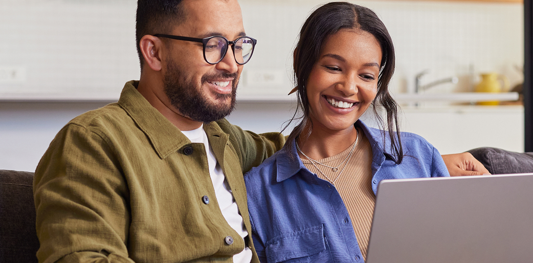 smiling couple looking at laptop